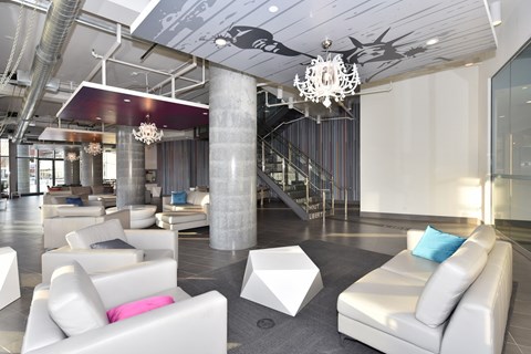 A modern living room with white furniture and a chandelier.