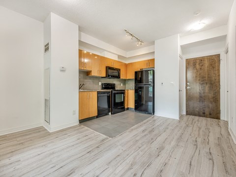 A kitchen with wooden cabinets and black appliances.