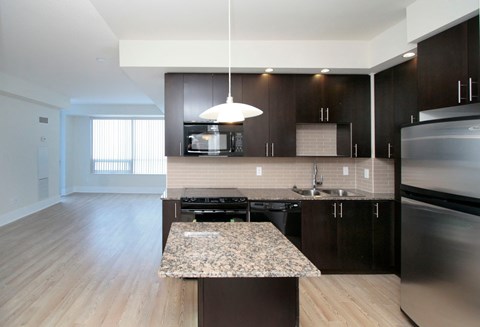A modern kitchen with dark wood cabinets and stainless steel appliances.
