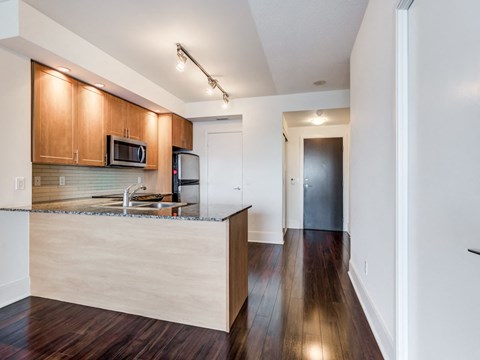 A kitchen with wooden cabinets and a granite countertop.