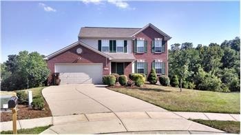 A two-story house with a garage and a driveway.