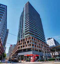 A tall building with a lot of windows in the middle of a city.