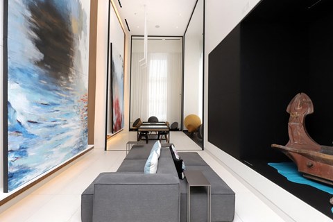 A large painting hangs on the wall in a modern living room.