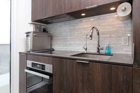 A kitchen with a sink and an oven.