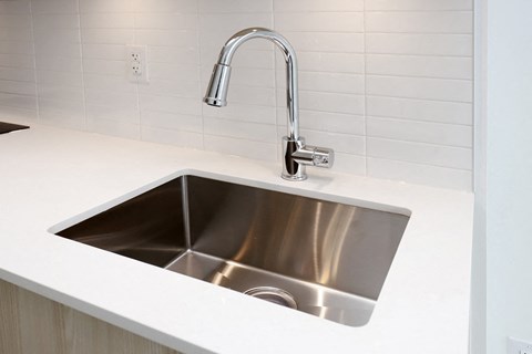 A modern kitchen sink with a chrome faucet.