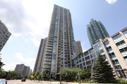 A tall building stands in the middle of a city park.