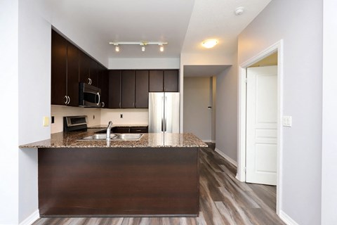 A kitchen with brown cabinets and a brown island.