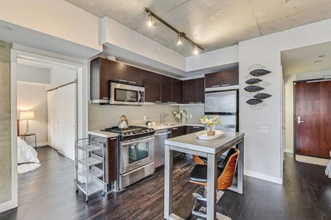 A kitchen with a table and chairs in the middle of it.