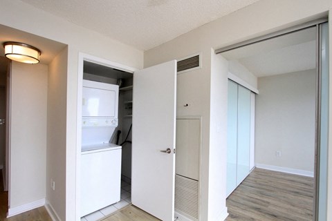 A white refrigerator is in a kitchen with a white door.