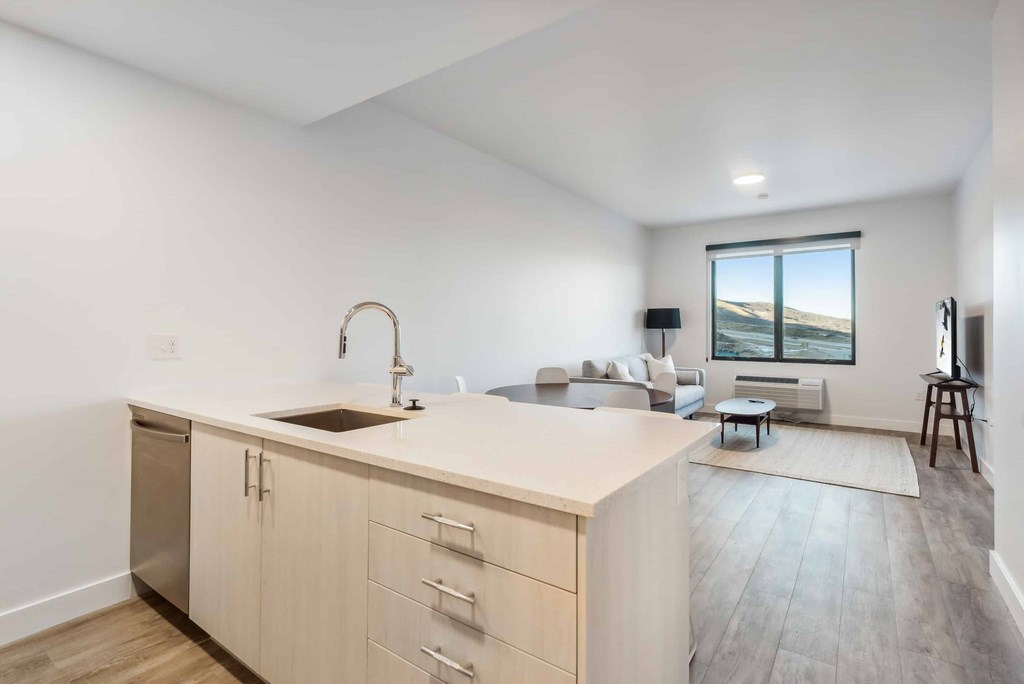 A modern kitchen with a large island and a view of the beach.