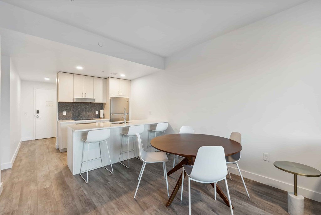 A dining room with a table and chairs.