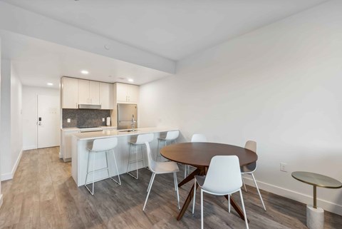 A dining room with a table and chairs.