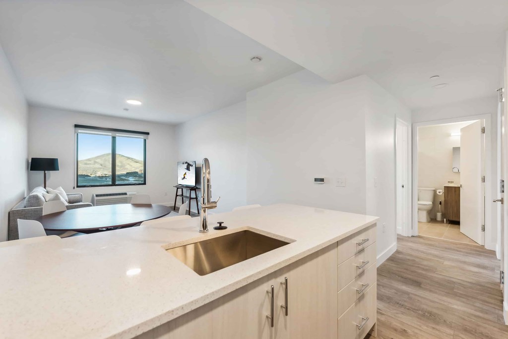 A modern kitchen with a large island and a view of the outdoors.