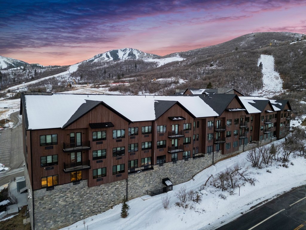A large building with a lot of windows is surrounded by snow.
