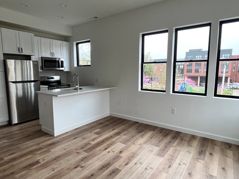 A kitchen with a refrigerator, microwave, and sink.