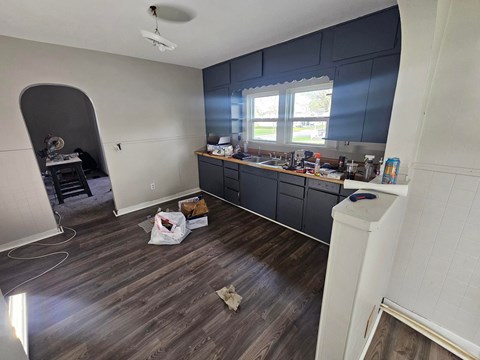 A room with a kitchen counter and a ceiling fan.