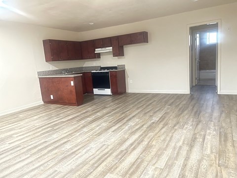 A kitchen with wooden cabinets and a countertop is empty and ready for furnishing.