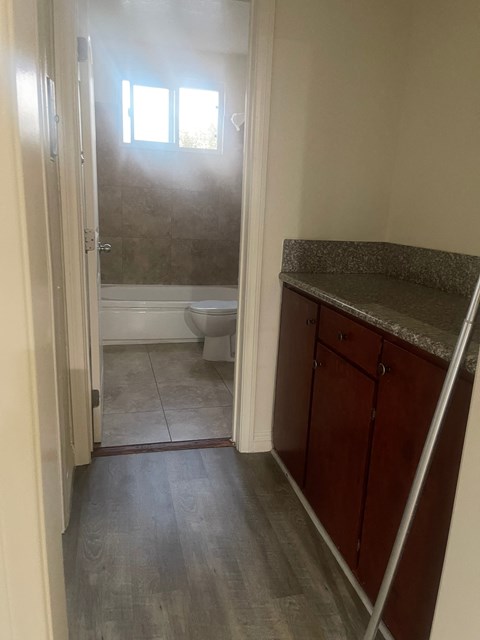 A bathroom with a toilet, sink, and a window.