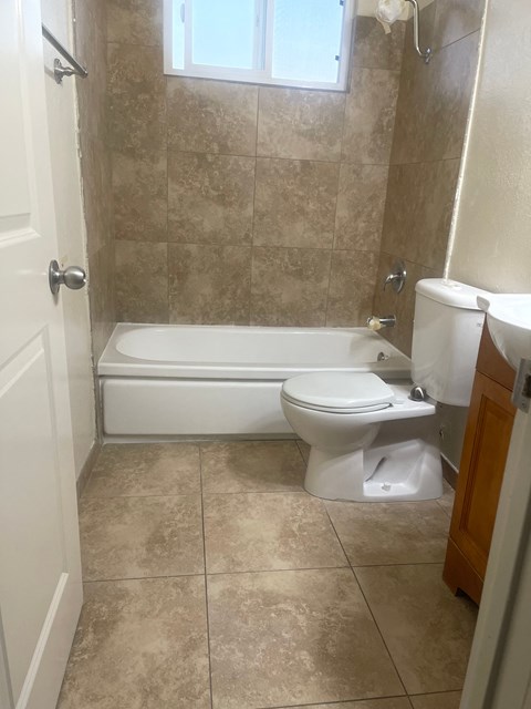 A bathroom with a toilet, tub, and sink.