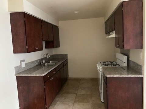 A kitchen with brown cabinets and a white stove.