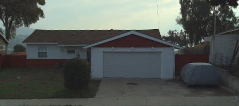 A house with a red roof and a white garage door.