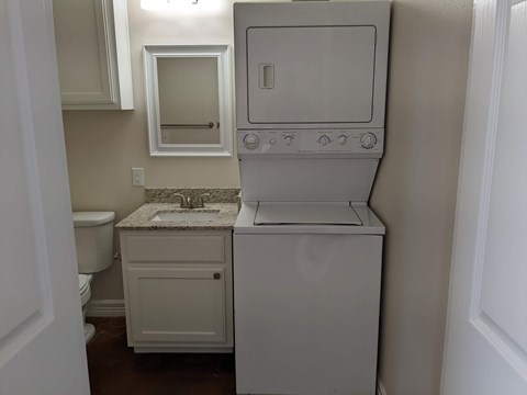 A white washer and dryer in a small bathroom.