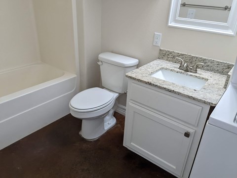 A white toilet sits next to a sink in a bathroom.