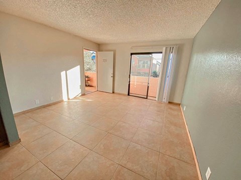 A room with tile flooring and a door leading outside.