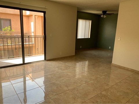 Empty room with tiled floor and sliding glass door.