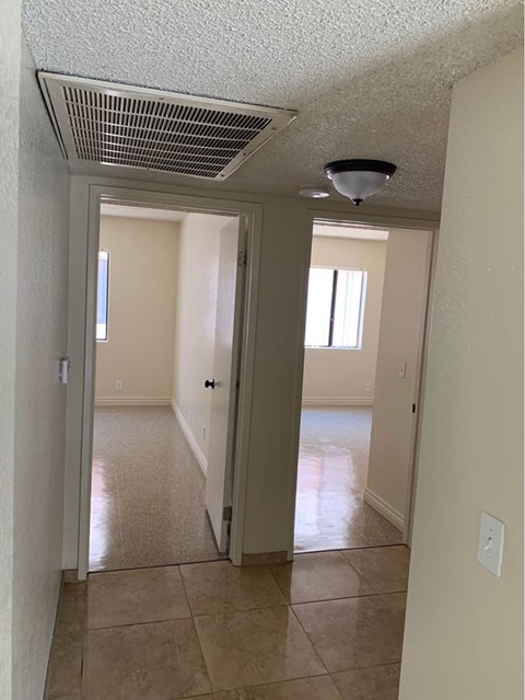A hallway with a tiled floor and a light on the ceiling.