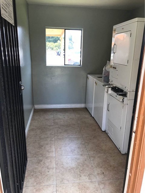 A small room with a fridge and a window.