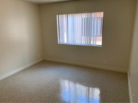 A room with a window covered by blinds.
