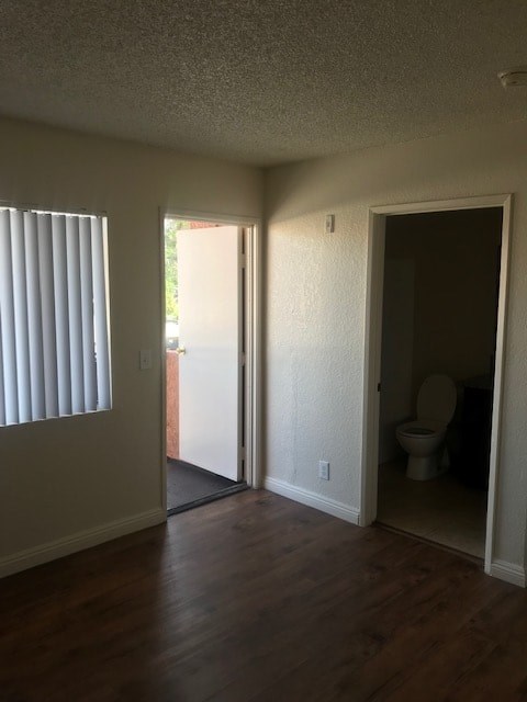 A room with a toilet in the other room.