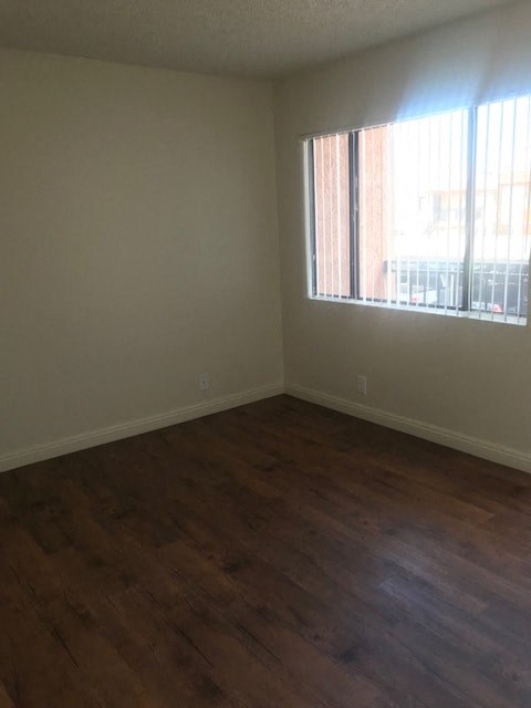 A room with a window and wooden flooring.