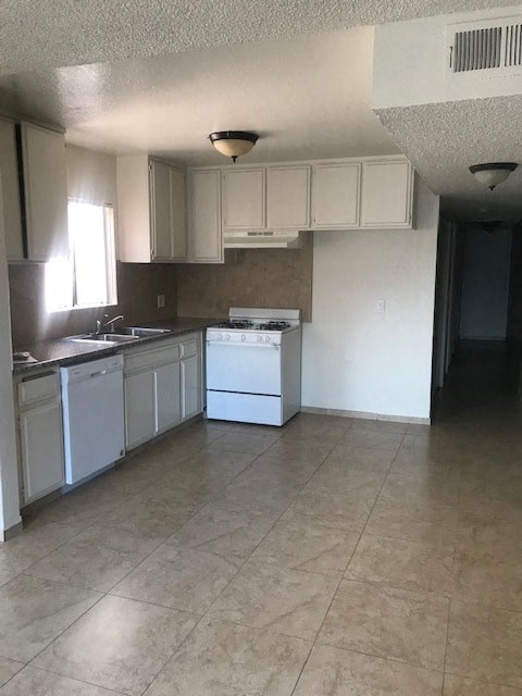 A kitchen with white appliances and cabinets.