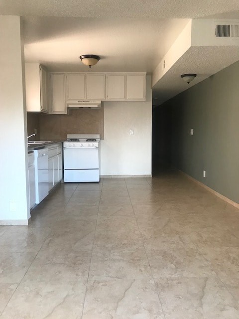 A kitchen with white appliances and cabinets.