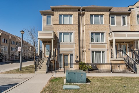 A row of townhouses with a clear blue sky above.