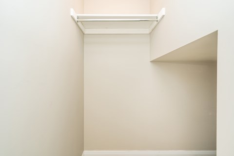 A white shelf is mounted on a wall.