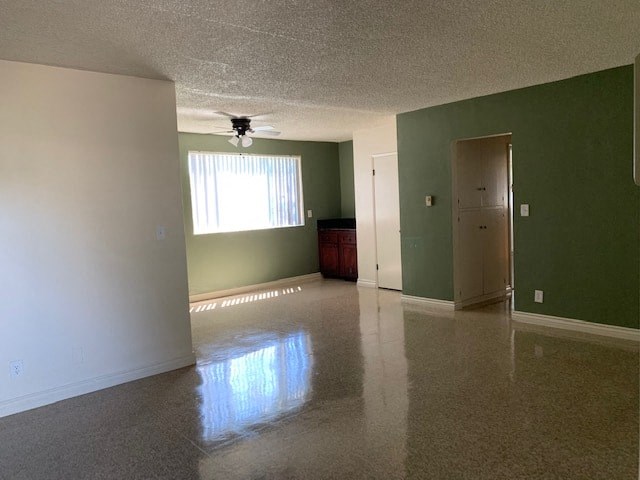 A room with a ceiling fan and a window with blinds.