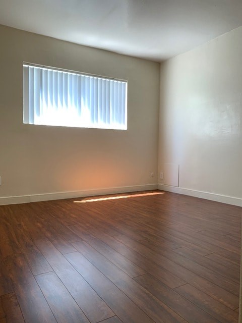 A room with a window and wooden flooring.