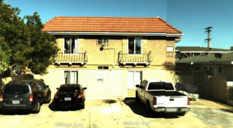 A house with a red roof and a car parked in front.