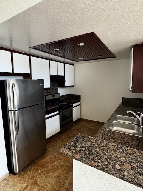 A kitchen with a refrigerator, sink, and stove.