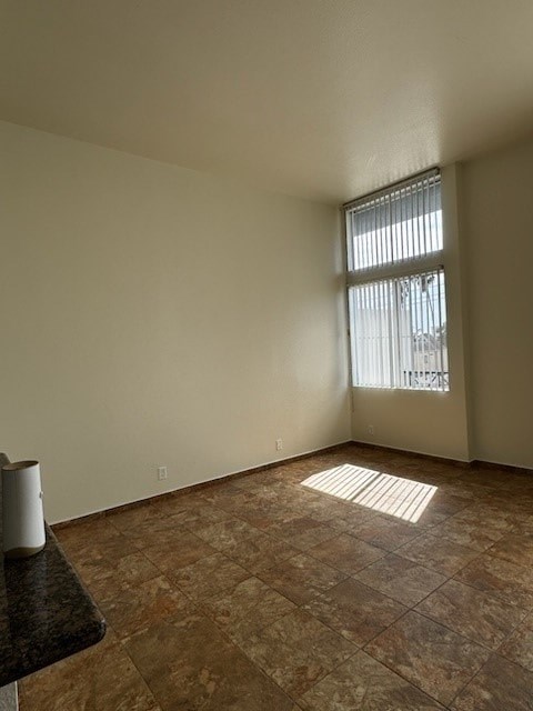 A room with a tile floor and a window with blinds.