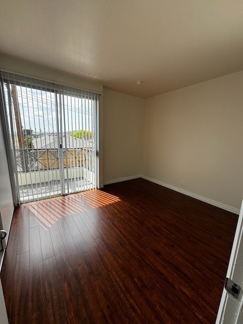A room with wooden flooring and a sliding glass door.