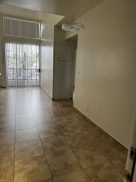 A hallway with tiled floors and a door on the right.