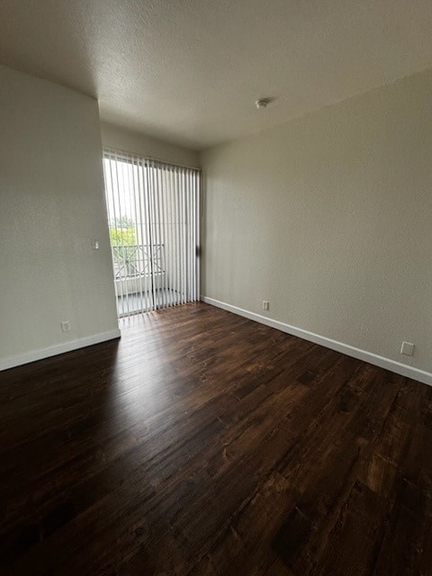 A room with wooden floors and a sliding glass door.