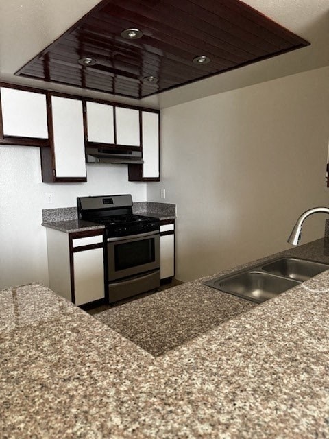 A kitchen with a granite countertop and stainless steel sink.