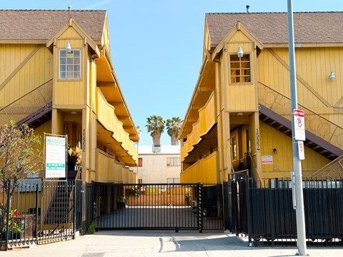 A yellow building with a black gate in front.
