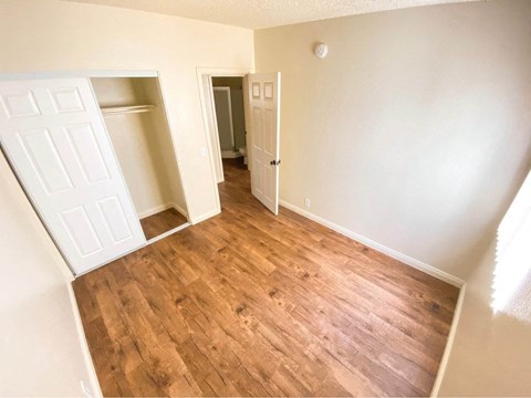 A room with wooden flooring and white walls.