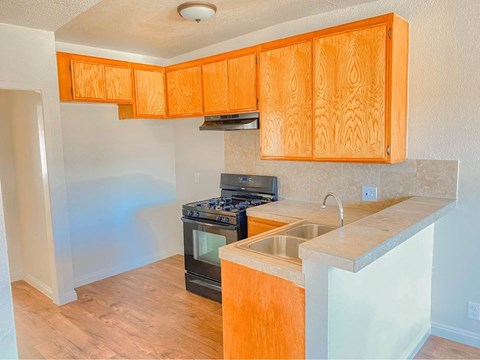 A kitchen with wooden cabinets and a black stove top oven.